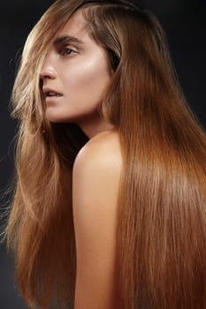 Beautiful young brunette woman with long, silky, straight hair and glowing skin. Haircare beauty portrait highlighting shine, health, and salon-style smoothness. Concept of keratin treatment, hair botox, and professional straight hair care.