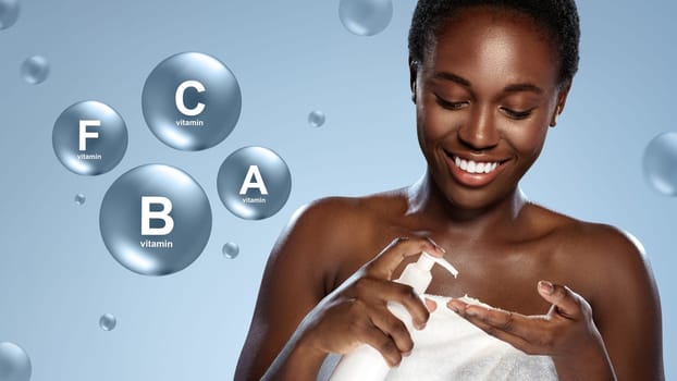 A woman with dark skin applies a skincare product to her hand, showcasing a joyful expression. Behind her, vitamins are highlighted, suggesting benefits for skin health.