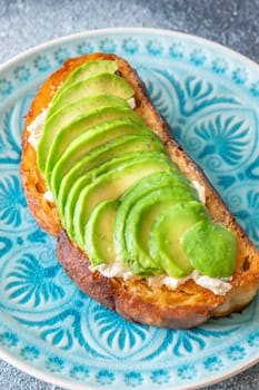 Bright avocado rests on creamy labneh, textures contrast beautifully on toasted bread