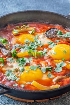 Eggs simmered in spiced tomato base with mushrooms, peppers, and fresh herbs