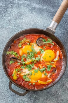 Eggs simmered in spiced tomato base with mushrooms, peppers, and fresh herbs