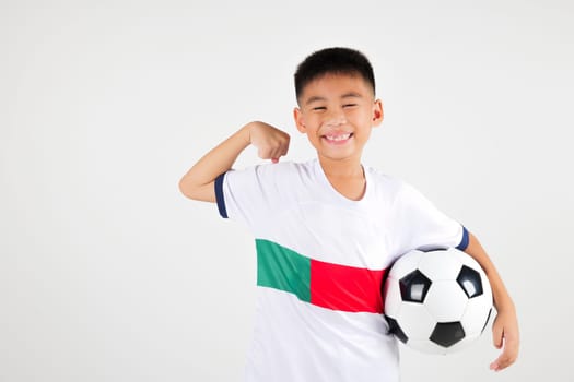 Portrait Asian smiling young boy kids holding soccer ball and power strong studio shot isolated white background, cute child playing football show muscle, sport hobby for kids, leisure games