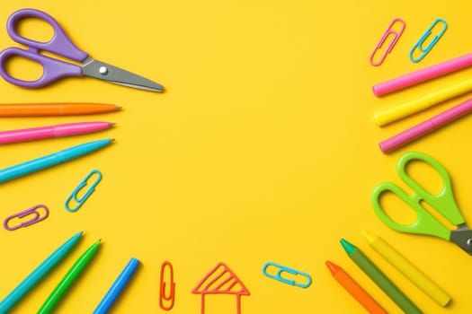 Vibrant flat lay with school and art supplies such as pens, crayons, scissors and clips on a bright yellow background. Perfect for educational promotions, creative projects or classroom visuals
