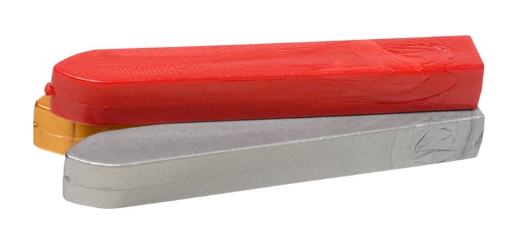 Three sticks of sealing wax in red, gold and silver colors lying on each other, isolated background
