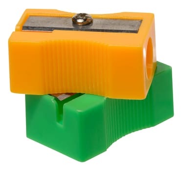 Orange and green plastic pencil sharpeners on isolated background