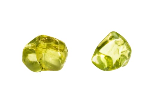 close up of sample of natural stone from geological collection - two tumbled peridot minerals isolated on white background