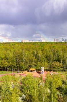 sunlit playground and green city park after rain on sunny spring day