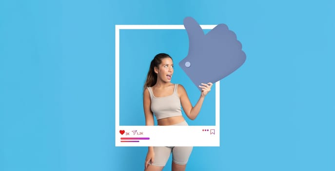 A social media influencer poses playfully with a thumbs up against a bright blue background. The lively atmosphere enhances her excitement for online engagement and content creation.