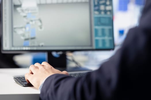 Solar panels manufacturing technician developing new photovoltaic materials and technologies using PC. Close up of photovoltaics factory expert conducting experiments on computer