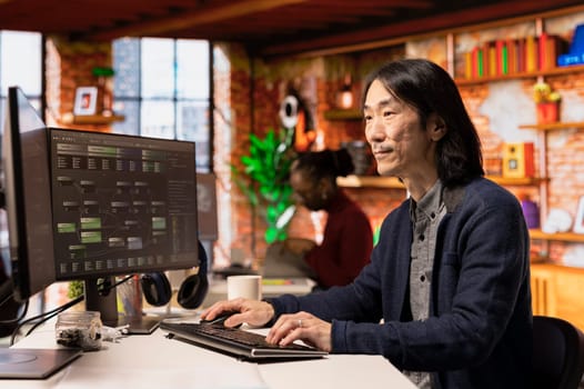 Senior technician working in innovative startup office using programming languages to build application. Experienced software development agency IT CTO manager optimizing code on computer