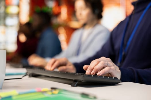 Call center agent typing on PC keyboard, assisting customers through digital communication channels. Customer support employee using computer to have conversation with client in live chat, close up