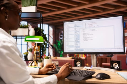 System administrator in apartment office types code into PC, developing software. IT professional at home fixing errors in application, implementing new features, listening music, close up shot