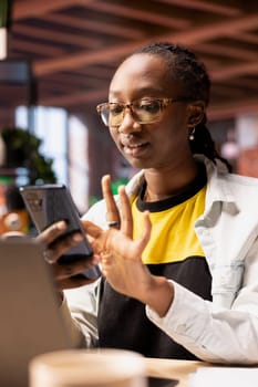 Upbeat woman at home browsing internet on mobile phone, researching information online. Relaxed person in apartment using search engine on smartphone device to find relevant info
