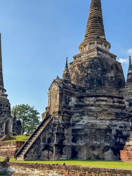People visiting the famous Wat Maha That Buddhist temple landmark, peaceful sacred place of worship with ancient construction. Historical Thai heritage and culture, brick monument.