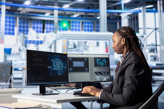 Engineer coding in solar panel plant, using artificial intelligence to automate equipment processes. Photovoltaics factory programmer writing scripts to optimize robotic operations using AI tech