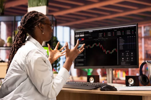 Frustrated day trader feeling upset, looking at PC display, showing falling stock prices, red charts and losses. Investor overwhelmed while looking at drop in stock exchange shares on monitor