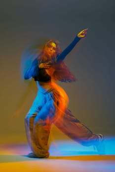 Jazz-funk dancer in vibrant motion blur, striking a bold pose with flowing lights and urban energy in a colorful studio setting.