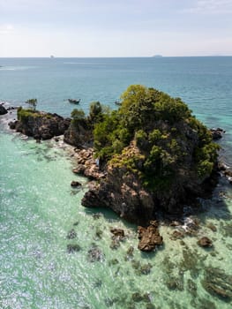 Majestic aerial view of a paradise dense island on Thailand shoreline, blue waters and the white sand beach make the palm trees glow in the sunlight. Luxurious resorts for a dream vacation.
