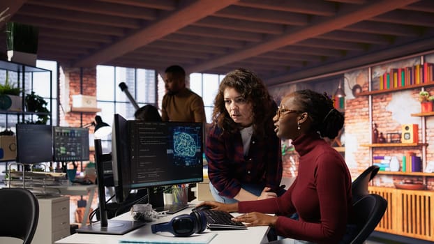 Teamworking engineers coding advanced AI algorithm and machine learning models enhancing automation. Employee talking with coworker in artificial intelligence Silicon Valley workspace, camera B