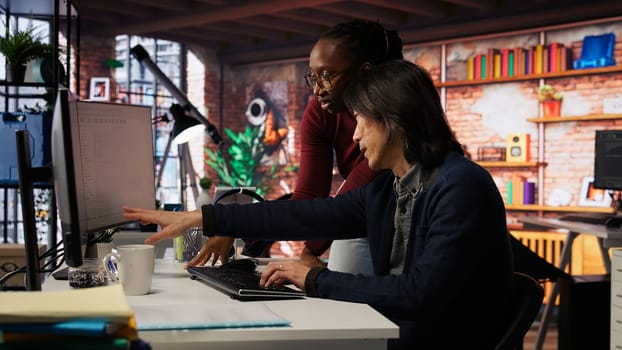 Programmer coming to AI startup office CTO manager desk to request help. Employee asks questions to senior team leader in artificial intelligence software development agency, camera B