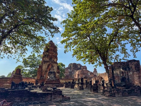 Sacred historical Thai landmark with multiple Buddha statues along the walls, Wat Maha That Buddhist ancient temples offer a serene religious atmosphere. Cultural heritage monument.