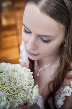 Bride holds a beautiful bouquet close while reflecting on her special day with the groom during their wedding registration.