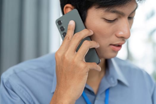 A focused business professional on a phone call, discussing project details, highlighting communication in a remote work environment.