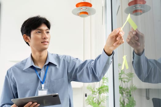 A businessman organizes ideas using sticky notes, illustrating creativity and strategic planning in a collaborative environment.