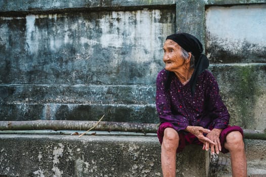 Old elderly Asian Vietnamese woman in village in Asia in Vietnam. Tam Thanh, Quang Nam province, Vietnam - April 10, 2025