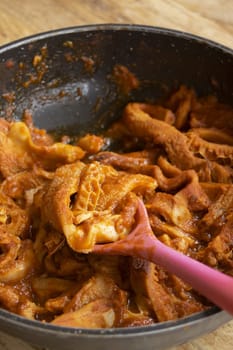 Traditional Roman Trippa alla Romana on a plate, with more cooking in pan. Classic Italian comfort food: tender tripe in rich tomato sauce with herbs.