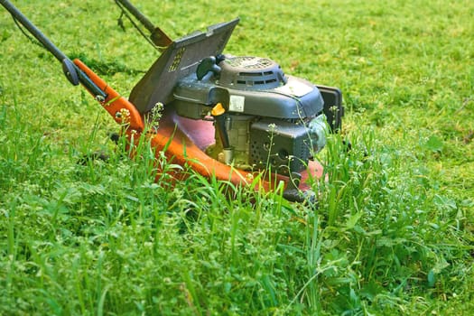 a handle electric or gasoline machine for cutting the grass on a lawn