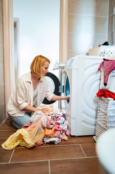 A woman organizes laundry in a cozy laundry room.