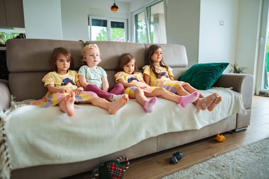 Kids dressed in vibrant outfits enjoy a cozy moment together.
