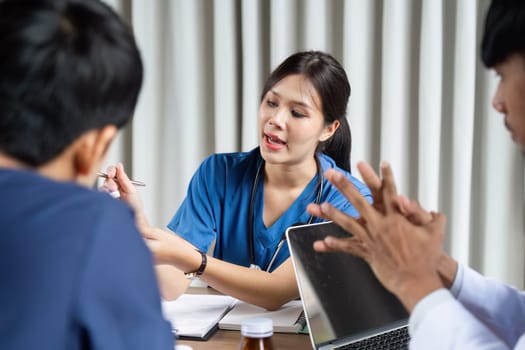 A nurse leads a discussion on patient information in a team meeting, ensuring clear communication and collaboration among healthcare professionals.
