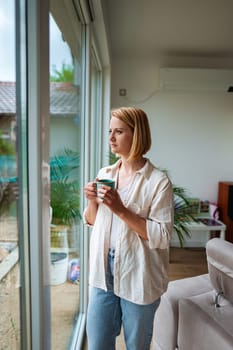 A woman enjoys a quiet moment while gazing outside.