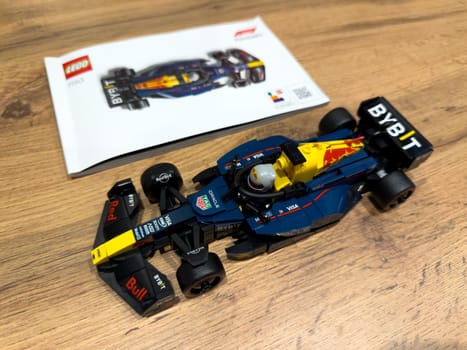 Moscow, Russia, April 26, 2025: Finished LEGO Red Bull Racing Formula 1 car displayed next to official instruction booklet, showcasing the complete result of the Speed Champions collaboration