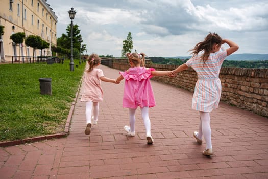 Children joyfully run together near Petrovaradin fortress.