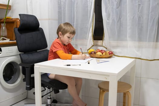 Preschool student drawing with colored pencils at home using an ergonomic chair