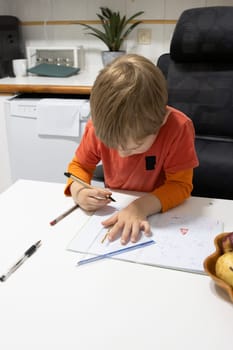 Preschool kid drawing and learning at home using ruler, pen and notebook
