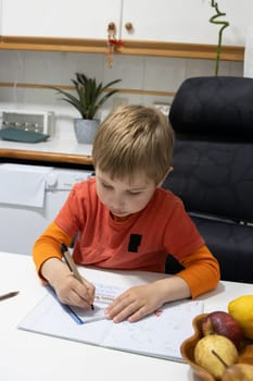 Young child learning and practicing writing on a notebook at home