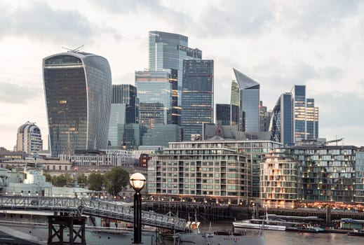 London, UK - Apr 27, 2025 - Gorgeous view of The Skyscrapers of Financial District by River Thames after sunset in City of London. use it as your Wallpaper, Poster and Space for text, Selective focus.