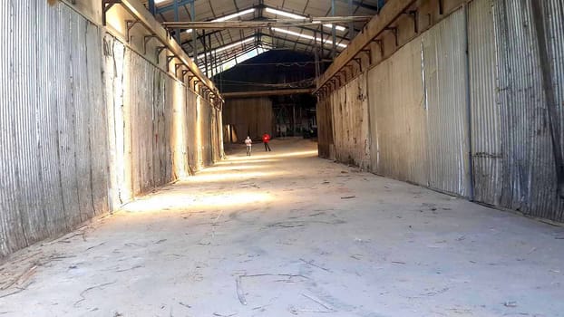 plywood processing plant showcasing Industrial Warehouse Interior with Stacks of Materials and Machinery, warehouse featuring industrial equipment, materials, and wooden pallets, highlighting productivity and organization.