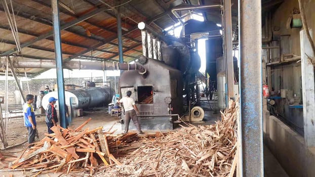 plywood processing plant showcasing Industrial Warehouse Interior with Stacks of Materials and Machinery, warehouse featuring industrial equipment, materials, and wooden pallets, highlighting productivity and organization.