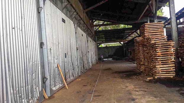 plywood processing plant showcasing Industrial Warehouse Interior with Stacks of Materials and Machinery, warehouse featuring industrial equipment, materials, and wooden pallets, highlighting productivity and organization.