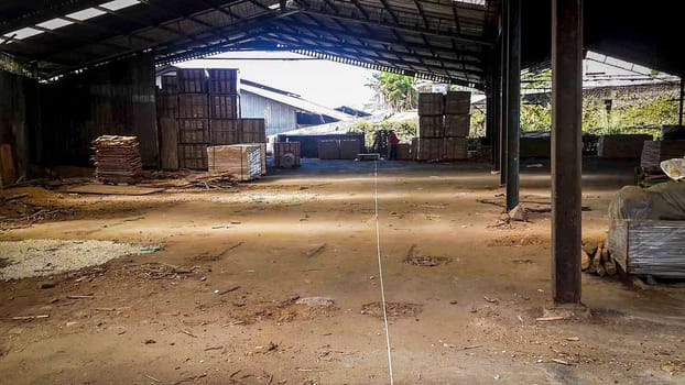plywood processing plant showcasing Industrial Warehouse Interior with Stacks of Materials and Machinery, warehouse featuring industrial equipment, materials, and wooden pallets, highlighting productivity and organization.