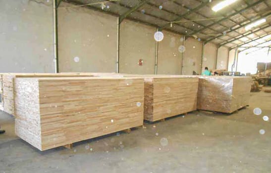 plywood processing plant showcasing Industrial Warehouse Interior with Stacks of Materials and Machinery, warehouse featuring industrial equipment, materials, and wooden pallets, highlighting productivity and organization.