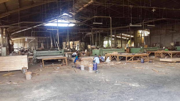 plywood processing plant showcasing Industrial Warehouse Interior with Stacks of Materials and Machinery, warehouse featuring industrial equipment, materials, and wooden pallets, highlighting productivity and organization.