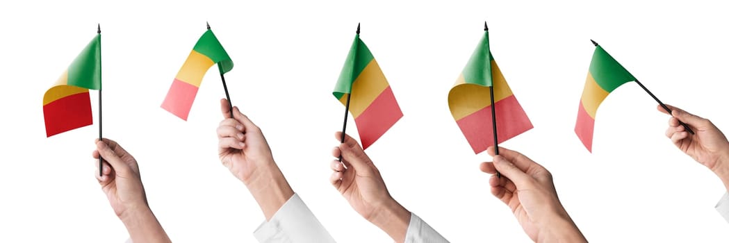 The Mali flag in hand in different angles on a white background.