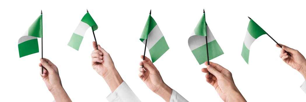 The Nigeria flag in hand in different angles on a white background.