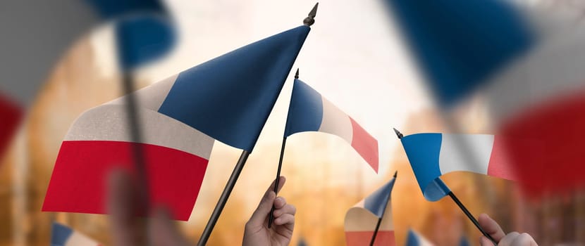 France flags in their hands on a blurred urban background. The photo illustration was created without the use of artificial intelligence, only using Photoshop.